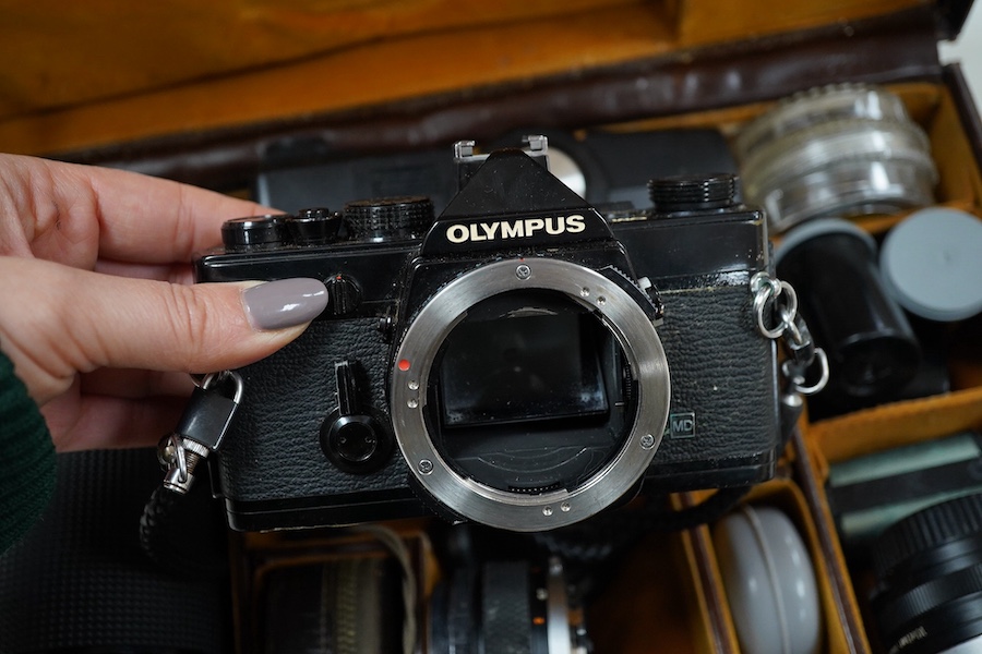 A cased Olympus camera, lenses and equipment, Condition - poor